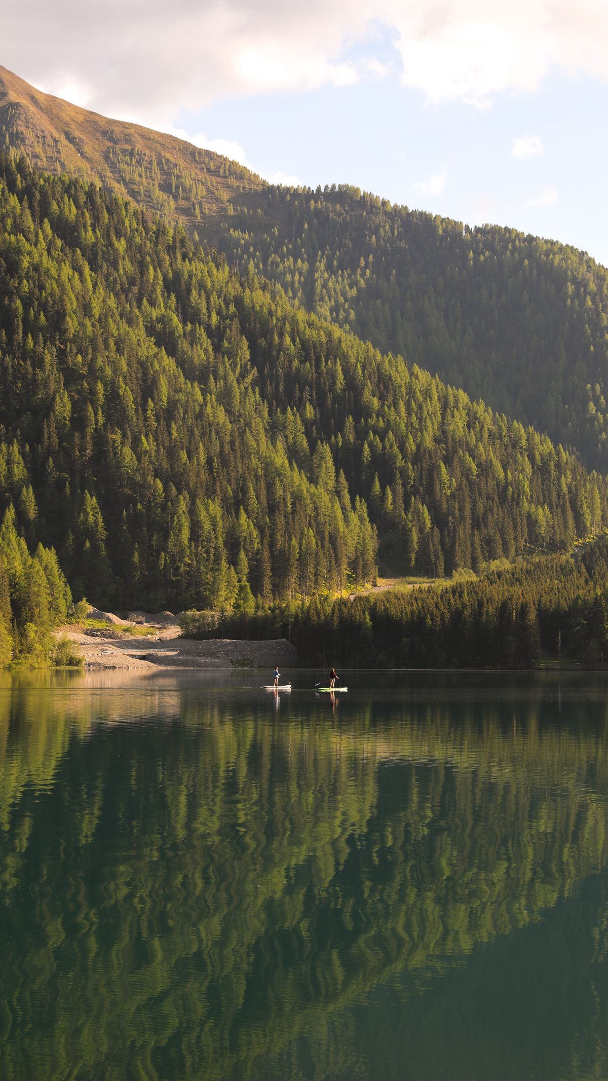 An alpine lake reflecting evergreen forest and mountain peaks